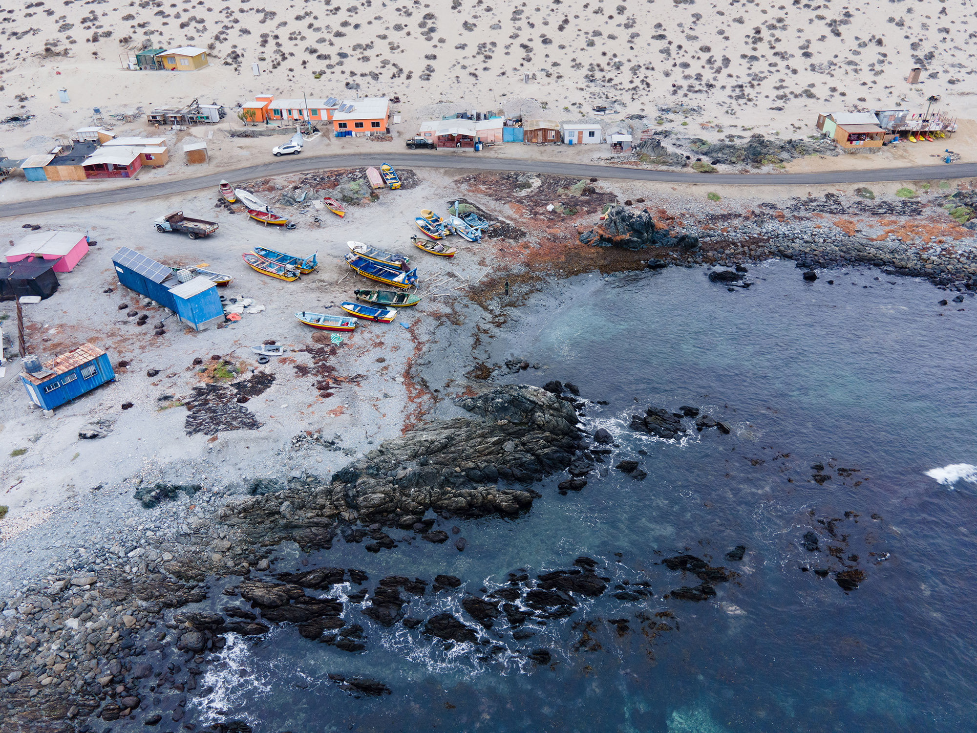 Una foto panorámica de Caleta Los Bronces, mostrando las casas, los botes y el mar.